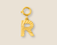 Gold letter 'R' charm on a beige background