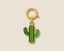 Gold green cactus charm on a beige background