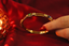 Side shot of multi-stone bangle with diamonds in 18K yellow gold