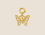 Gold butterfly pendant  charm on a beige background