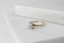 Product shot of 18K yellow gold solitaire ring with single emerald cut diamond