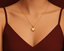 Gold necklace with a gold heart pendant/ charm on a mannequin neck.