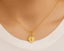 Gold heart-shaped necklace with key design on a person's neck