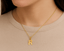 Gold necklace with a 'R' pendant on a plain background