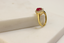 Product shot of classic ruby ring with Natural border for evening wear set in 18k yellow gold