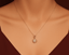 Gold necklace with a star-shaped pendant/ charm on a mannequin neck.
