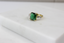 Side shot of diamond and emerald ring in 18K gold - perfect modern design