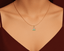 Necklace with a home pendant on a mannequin neck against a brown background