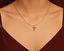 Gold necklace with a pizza-shaped pendant/ charm on a mannequin neck.